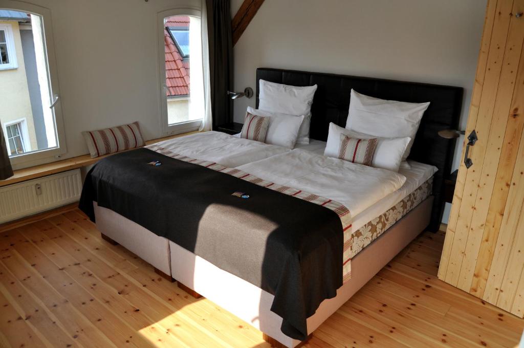 een slaapkamer met een groot bed met een zwart hoofdeinde bij Der Speicher in Wolgast