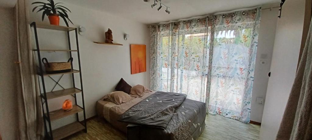 ein Schlafzimmer mit einem Bett und einem großen Fenster in der Unterkunft Chambre d hôte avec piscine in Agde