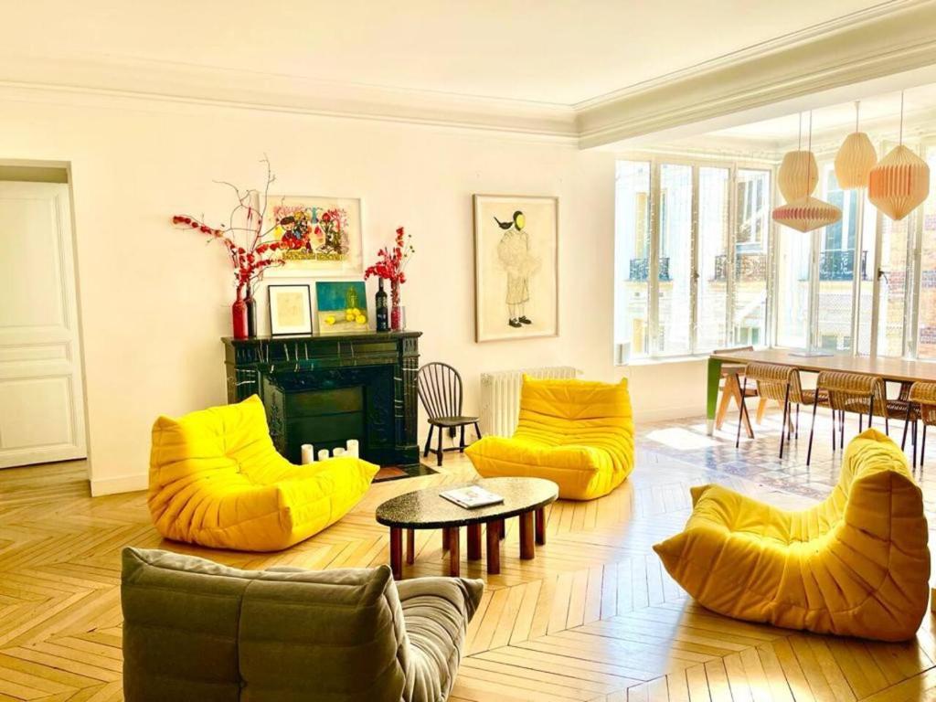 een woonkamer met gele stoelen en een tafel bij Grand Appartement - Tour Eiffel in Parijs