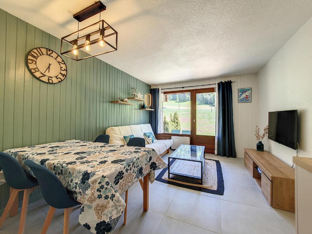 拉克呂薩的住宿－Verte vallée 4，客厅配有桌子和墙上的时钟
