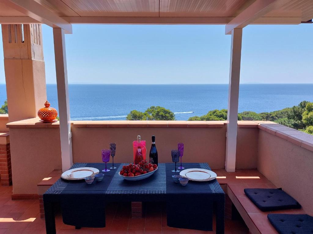una mesa con un bol de fruta en el balcón con vistas al océano en Capo d'Arco la Terrazza - Goelba en Capo D'Arco