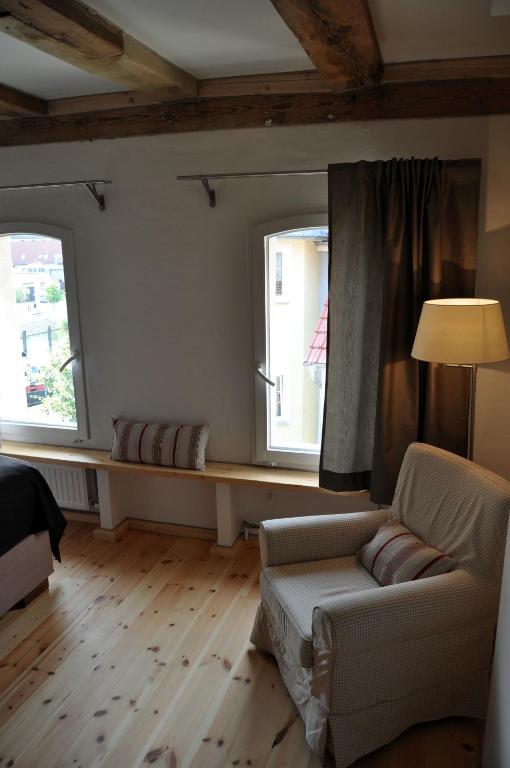 a living room with a couch and two windows at Der Speicher in Wolgast