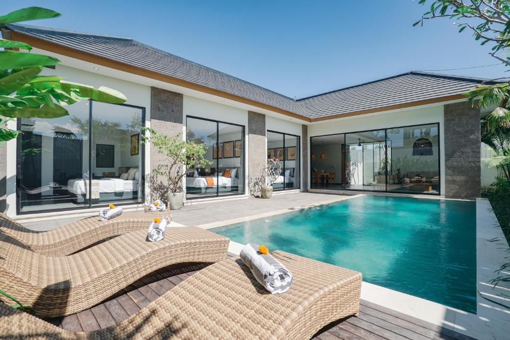 a villa with a swimming pool and a house at Villa Bunga Lily - Sumptuous 3BR Luxury Private Villa in Canggu in Canggu