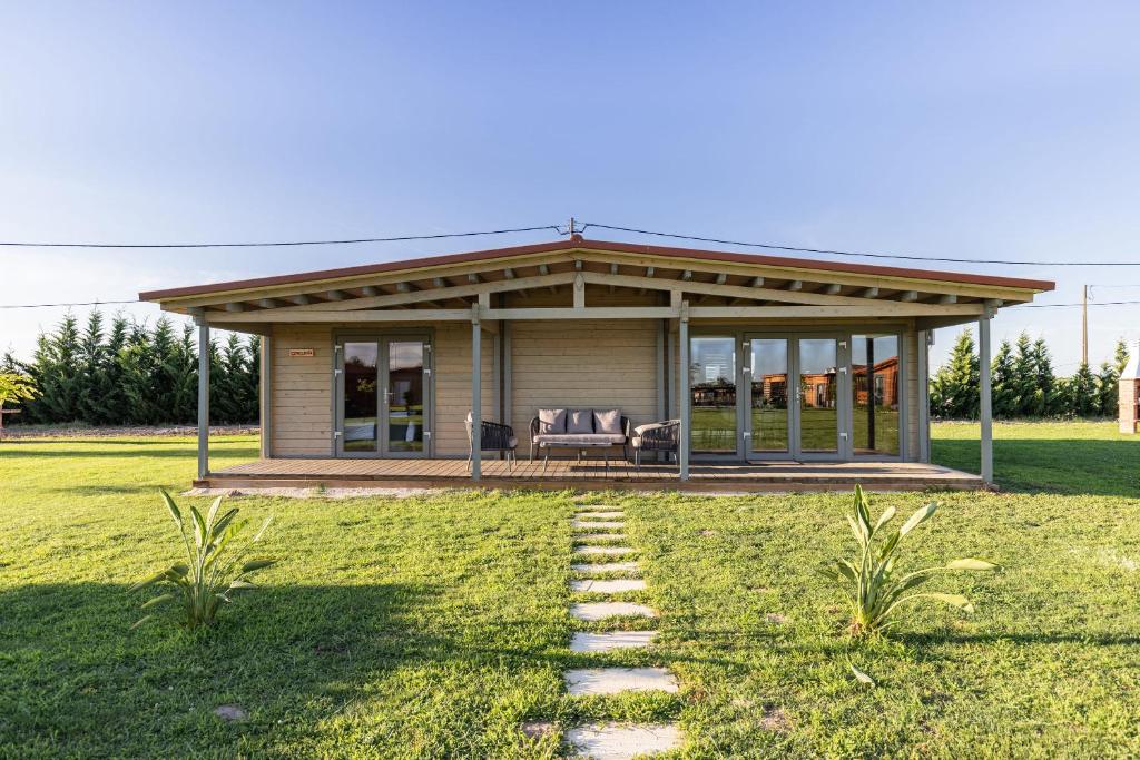 a small house with a porch and a lawn at CHALÉS DO TEJO 