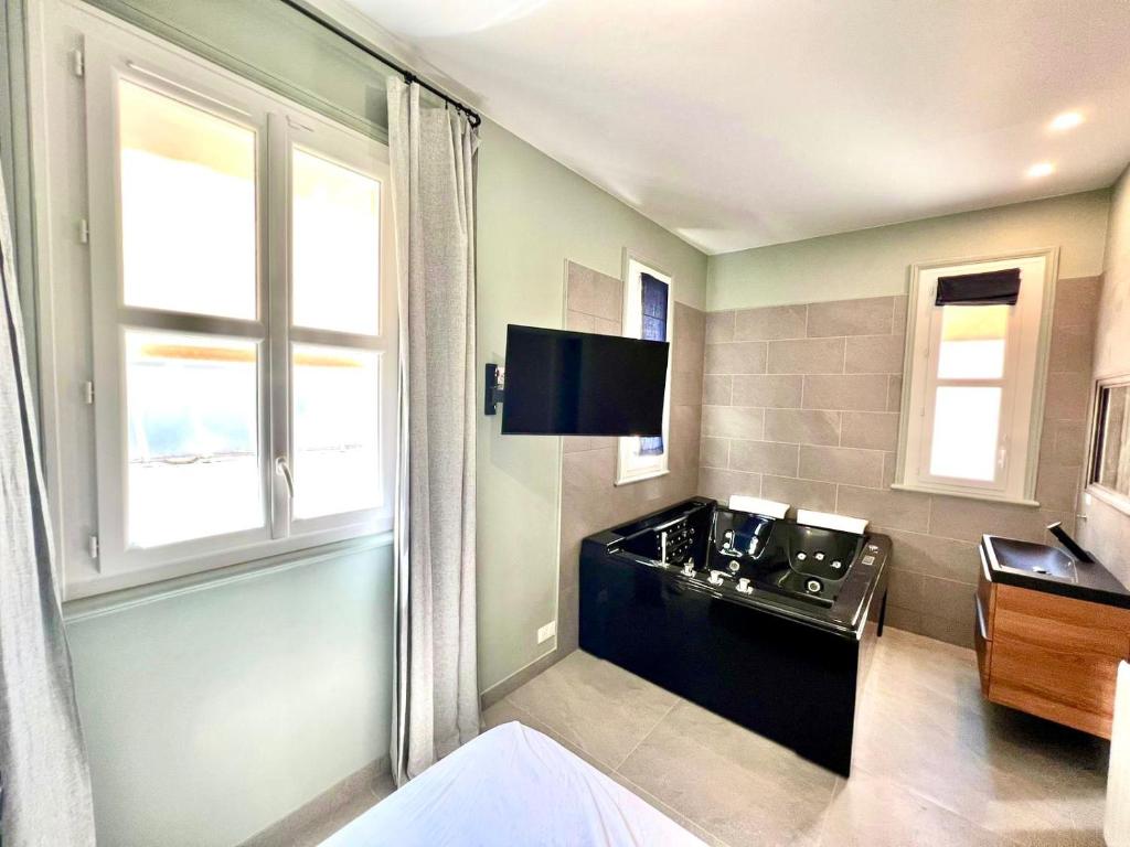 a bathroom with a sink and a flat screen tv at Palais Hervé in Cannes