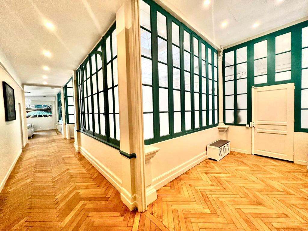 a hallway with large windows and a hard wood floor at Palais Hervé in Cannes