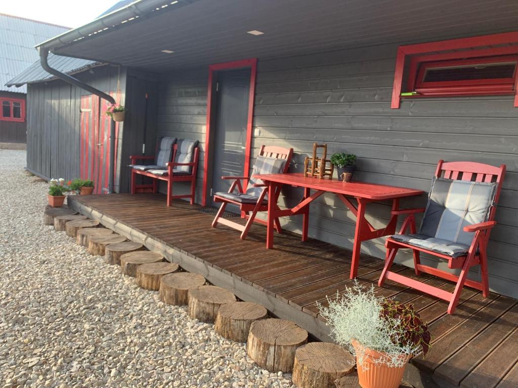 una terraza de madera con sillas y una mesa en una casa en Kakusoo õuemaja Piusa lähistel en Hanikase