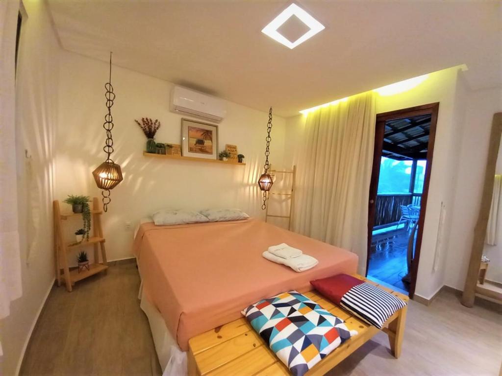 1 dormitorio con cama y banco. en Residencial Villa Jeri 2 SUÍTES a 300m do MAR, VARANDA, Smart TV, Wi-Fi, ar-condicionado en Jericoacoara
