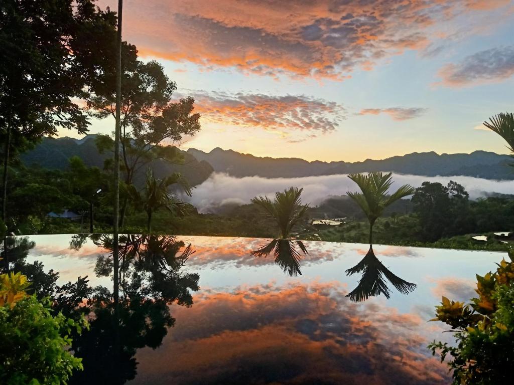 Blick auf einen See mit Palmen und Sonnenuntergang in der Unterkunft Puluong Home in Pu Luong