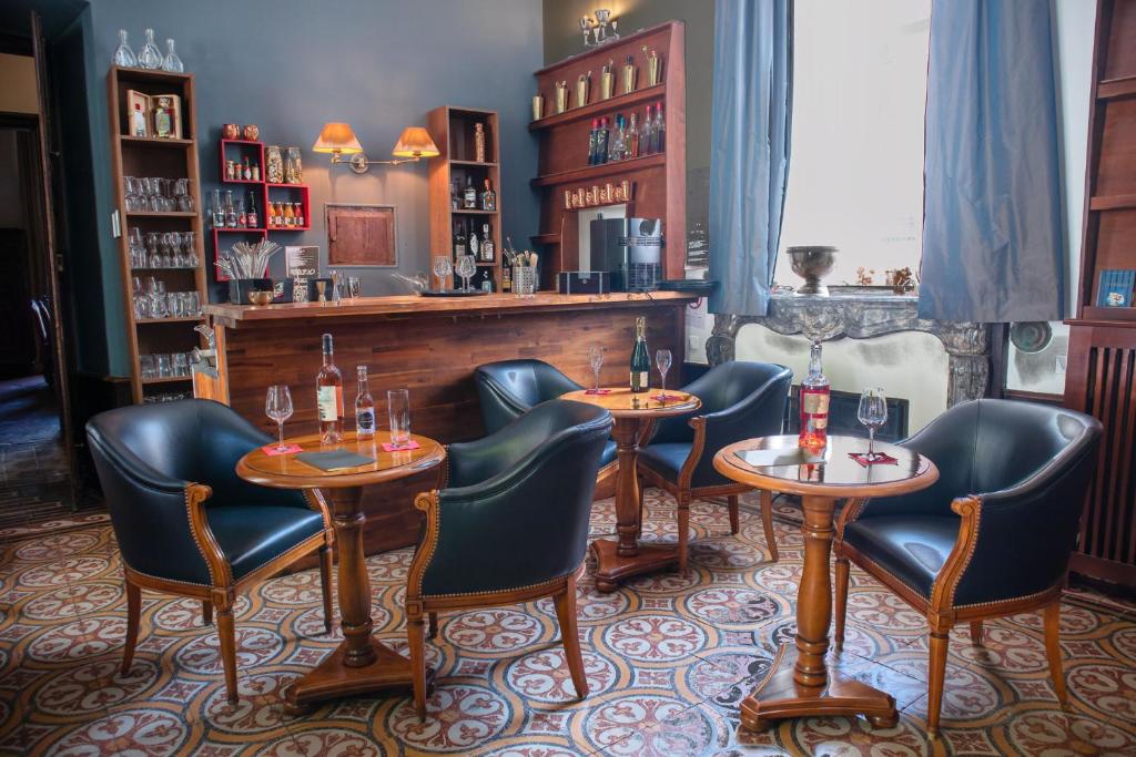 ミルポワにあるChambres d'hôtes Relais Mira Peisのテーブルと椅子2脚付きのレストラン、バー