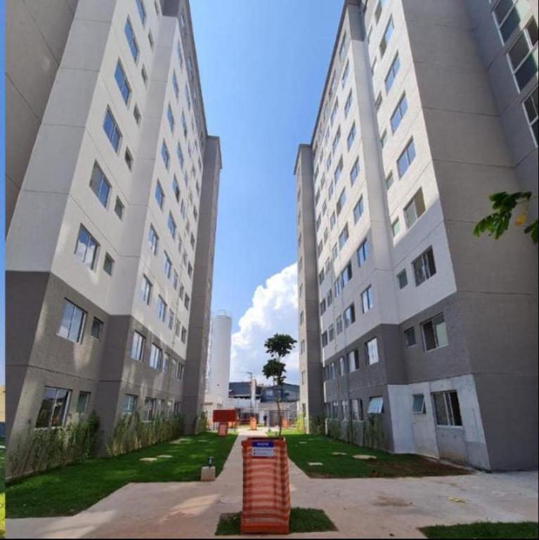 two tall white buildings with a trash can between them at Duo Interlagos Aluguel apenas do quarto in São Paulo