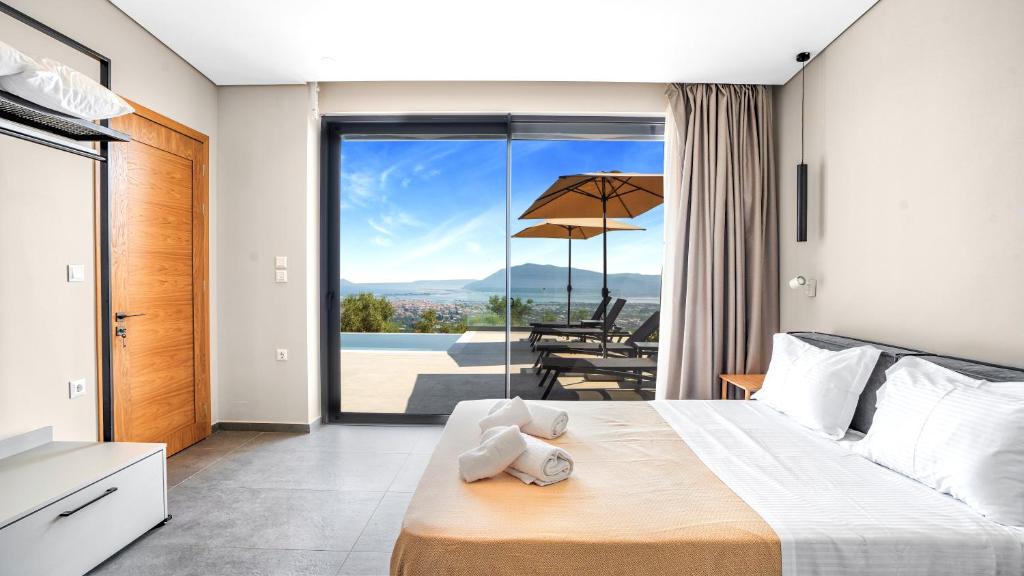 a bedroom with a bed with a view of a patio at Ecstasy Luxury Villas in Apolpaina