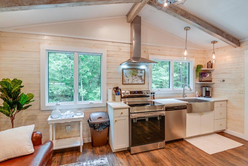 a kitchen with wooden walls and a stove top oven at Cozy Tennessee Retreat with Patio and Charcoal Grill! in Linden