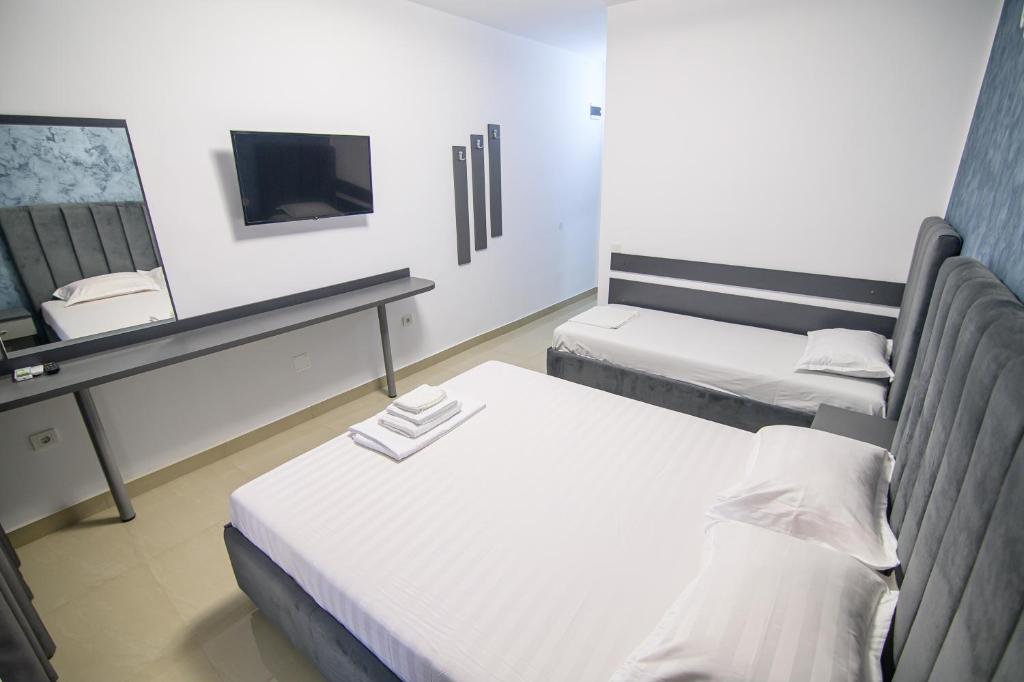 a small room with two beds and a tv at Cazare Dumbrava in Eforie Sud