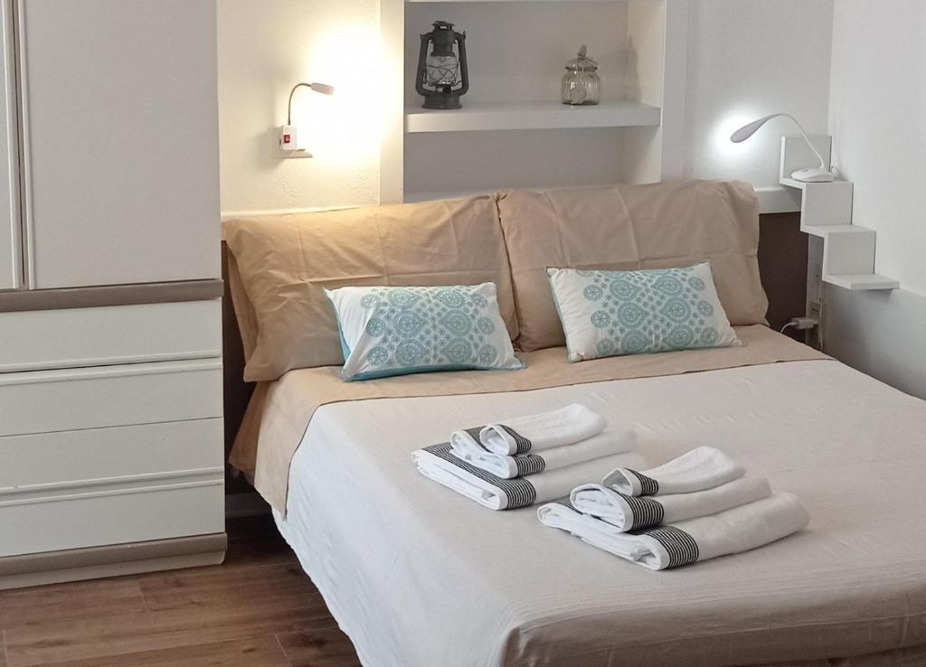 a bedroom with a bed with towels on it at Sa Frummiga in Cagliari