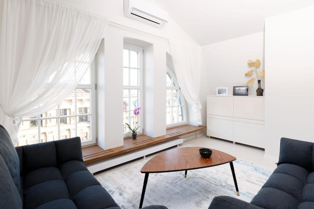 uma sala de estar com dois sofás e uma mesa em Bright attic flat in the centre em Riga