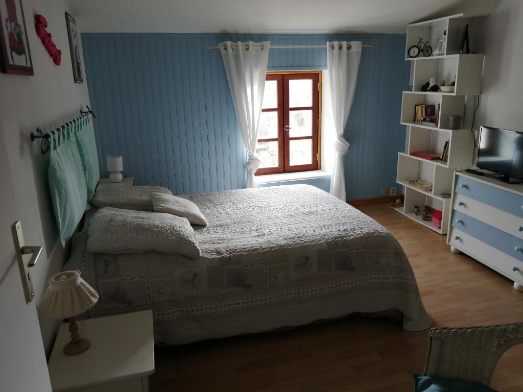 een slaapkamer met een bed en een raam bij Chambre d'hôtes Les Nénuphars in Melle