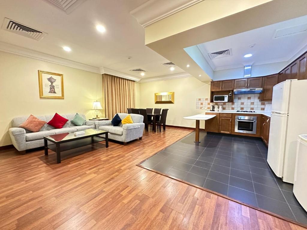 a living room with a couch and a kitchen at The Palace Suites in Al Khobar