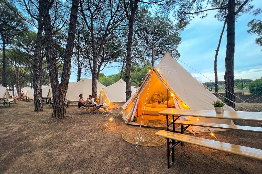 a group of tents in a field with people sitting around them at Kampaoh Palamós Internacional in Palamós