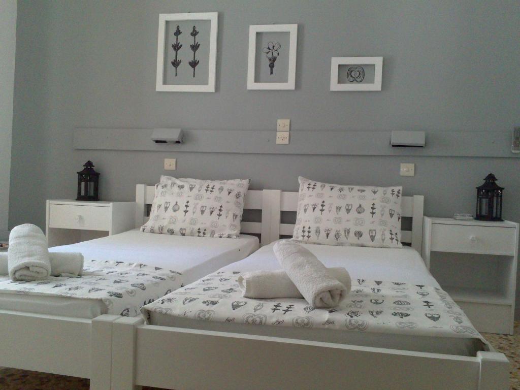 1 dormitorio con 2 camas con sábanas y almohadas blancas en Icarus Rooms, en Parikia