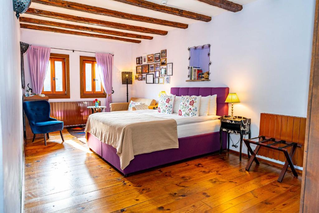 a bedroom with a large bed and a blue chair at Lavanda Restaurant with Rooms in Kovachevitsa