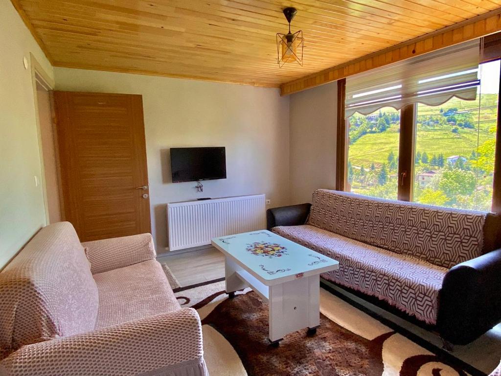 a living room with two couches and a table at Persembe House in Aybastı