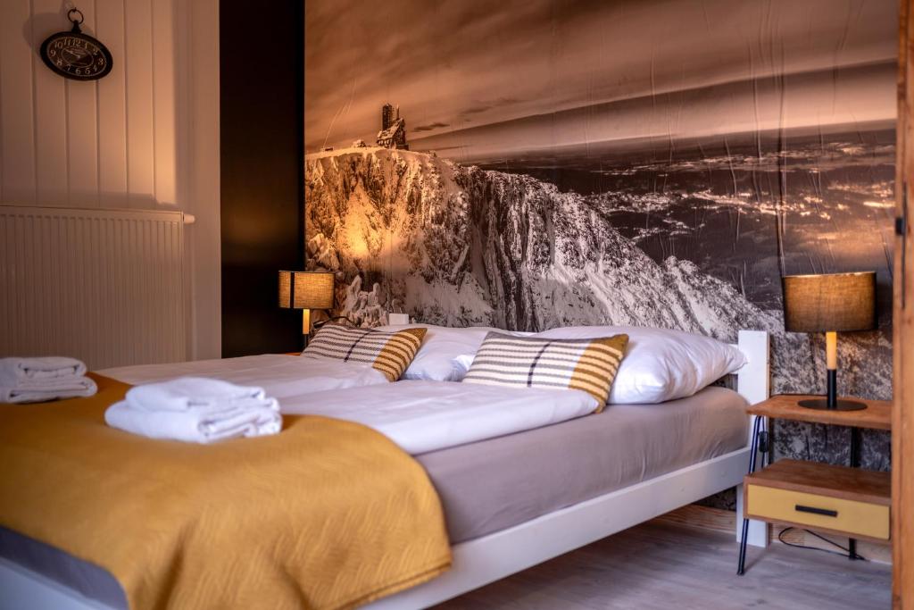 sypialnia z dużym łóżkiem z obrazem na ścianie w obiekcie Apartamenty Sudeckie nad zalewem II w mieście Sosnówka