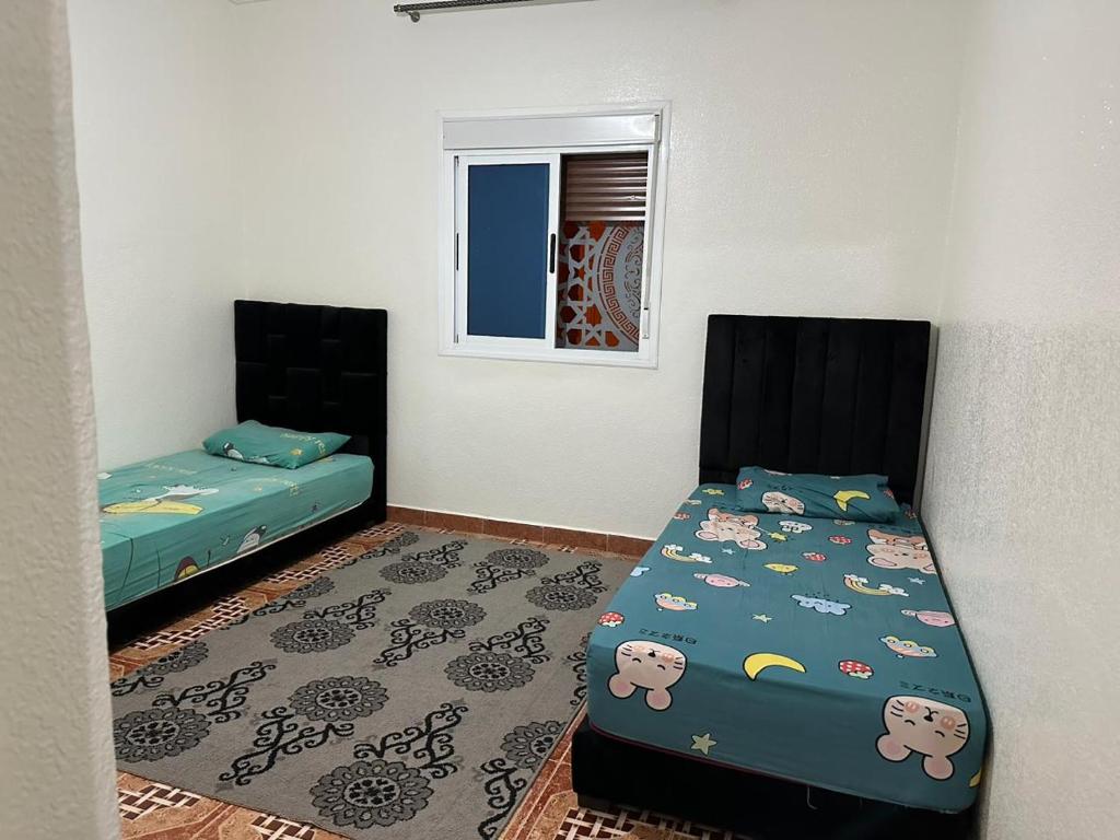 1 Schlafzimmer mit 2 Betten und einem Fenster in der Unterkunft إقامة الامل in Beni Mellal