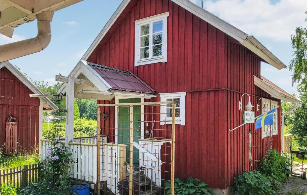 Um celeiro vermelho com uma cerca branca à frente. em Awesome Home In Tors With Kitchen em Brommösund