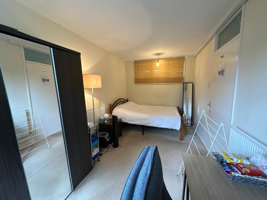 a small bedroom with a bed and a table at Private Room near Canary Wharf in London