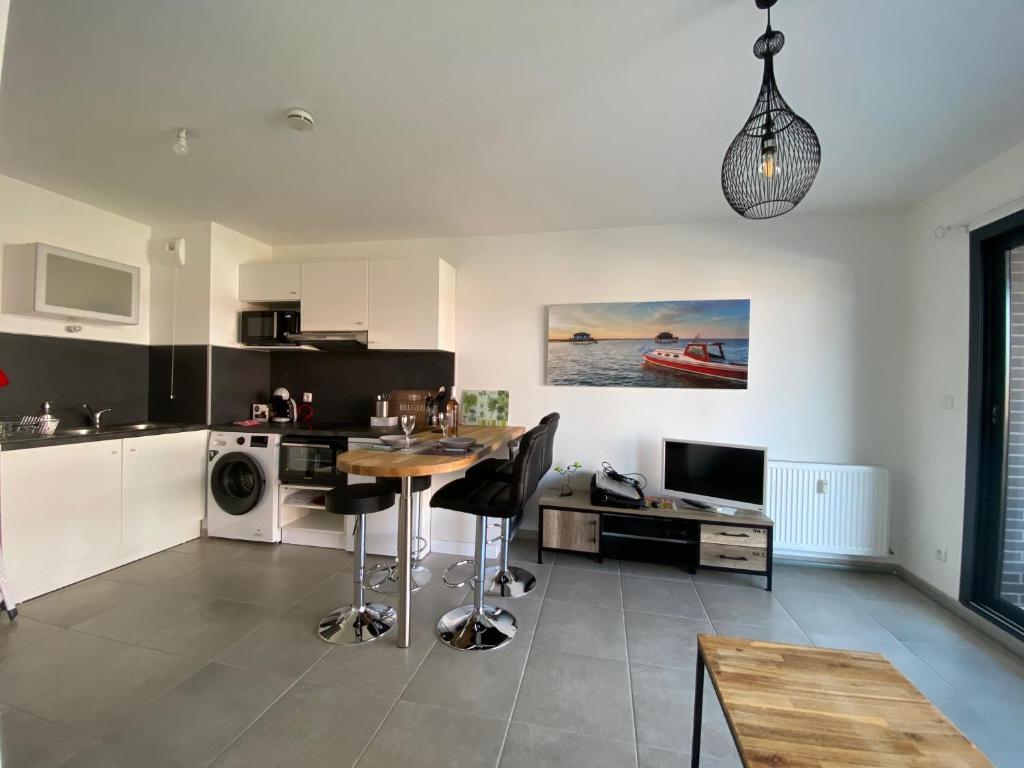 a kitchen with a table and chairs in a room at Bel appartement , à 2km du bassin d'Arcachon in La Teste-de-Buch