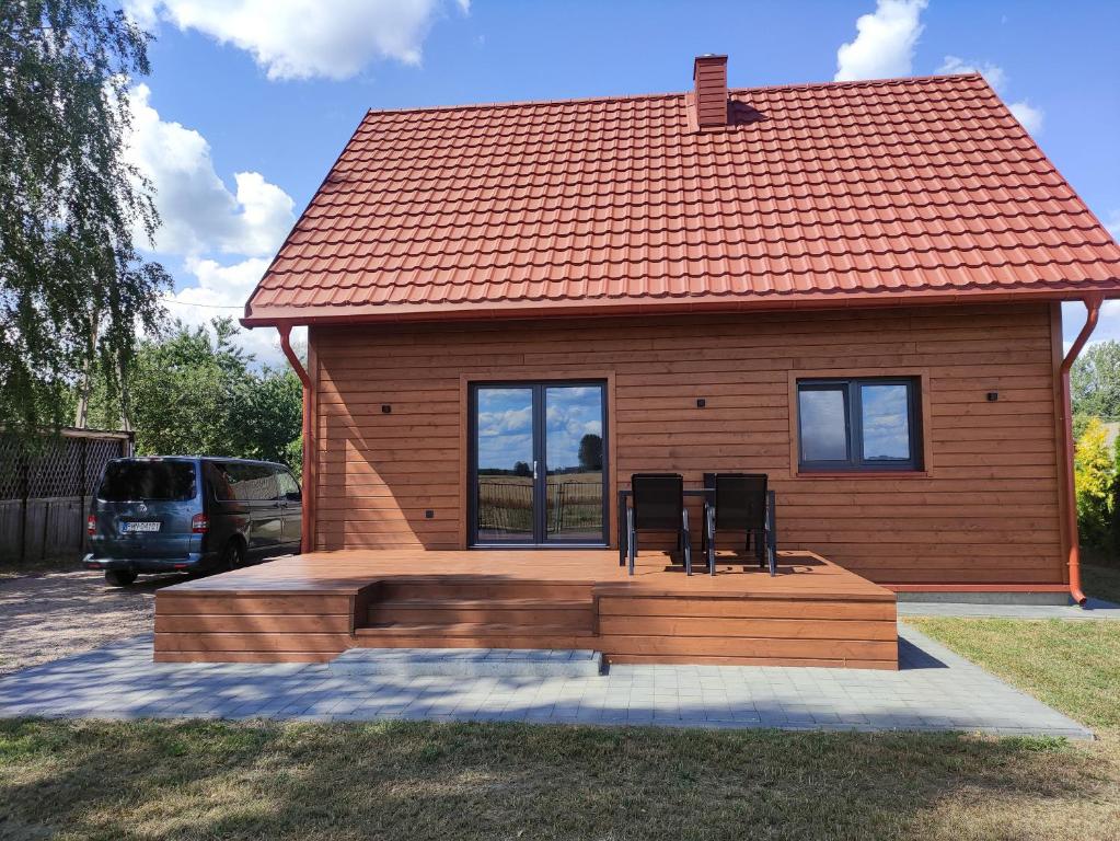 een klein huis met twee stoelen ervoor bij Dom nad Biebrzą - Siedlisko Wroceń 57 in Wroceń
