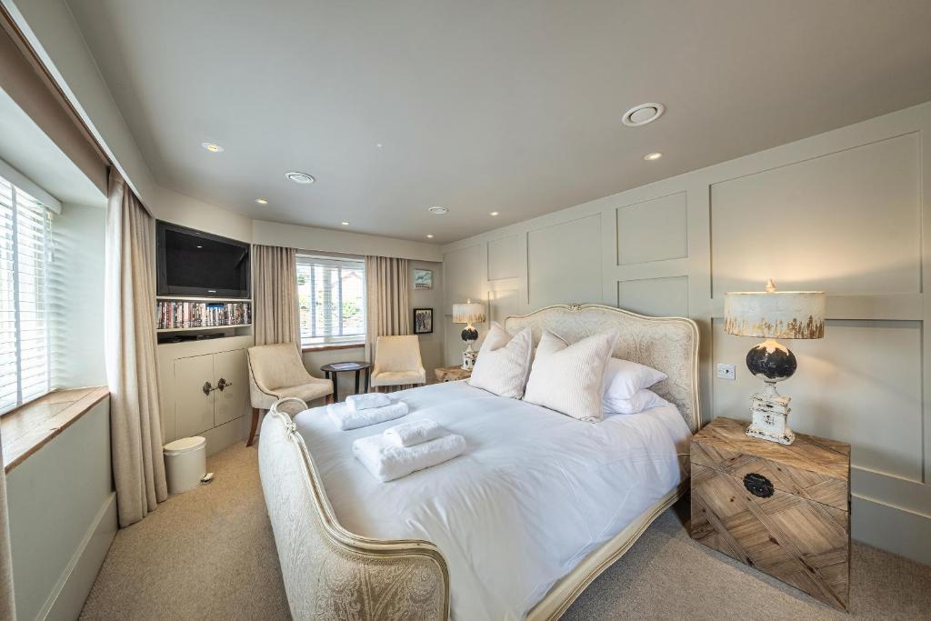 a bedroom with a large bed with white sheets and pillows at Wiveton Bell in Blakeney