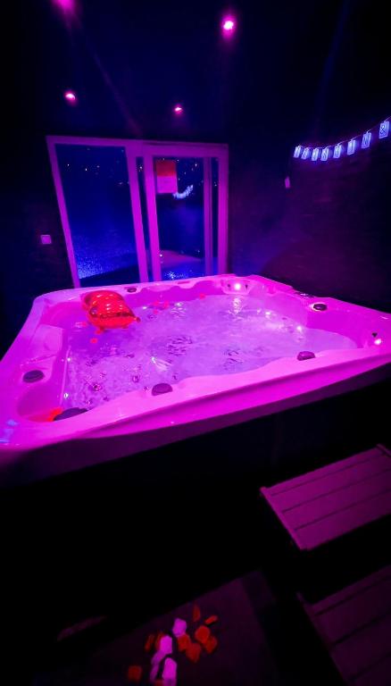 une baignoire rose dans une pièce sombre dans l'établissement Appart avec jacuzzi, et terrasse, à Marseille