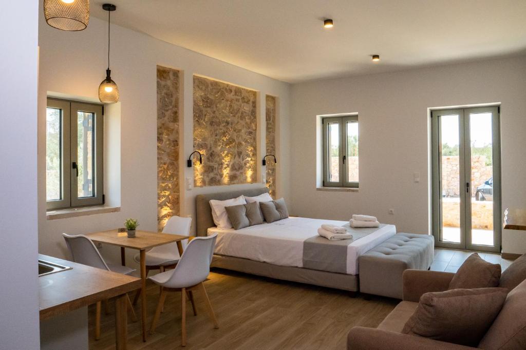 1 dormitorio con 1 cama y sala de estar en Olivar Suites, en Plitra