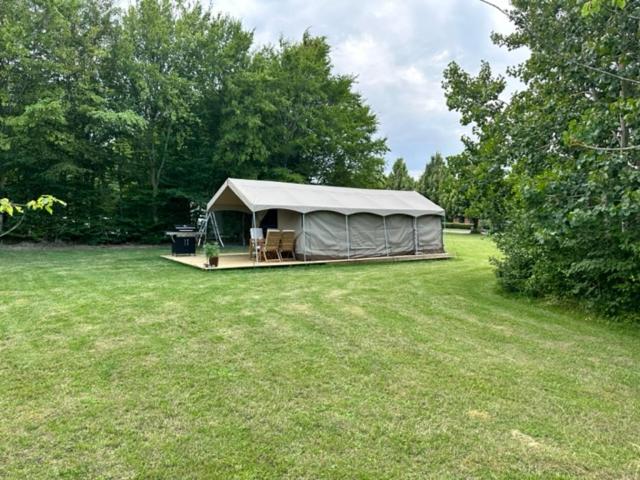 a tent in the middle of a grass field at Langø Feriecenter - Outdoor Lodge in Nakskov