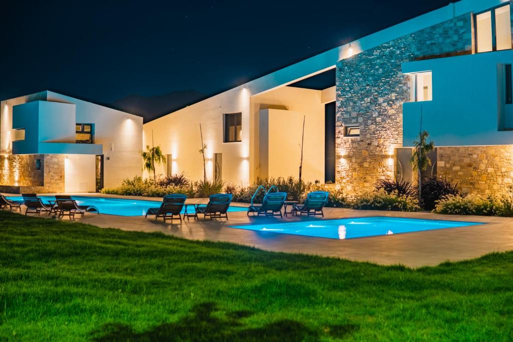 a house with a swimming pool at night at Itida Suites in Sitia