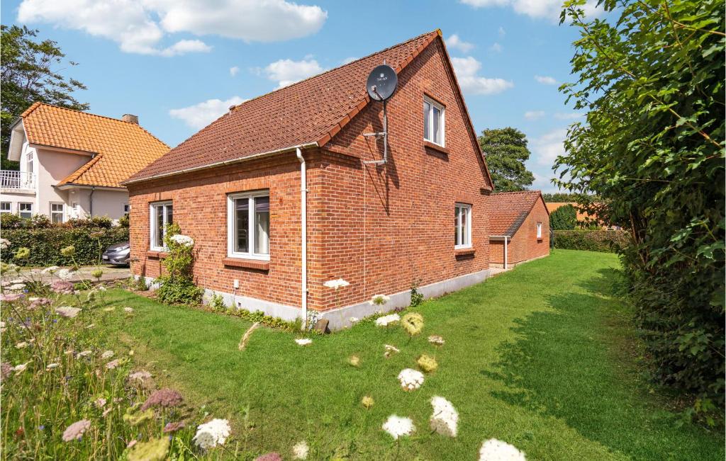 a brick house with a grass yard in front of it at 1 Bedroom Cozy Apartment In Ringkbing in Ringkøbing
