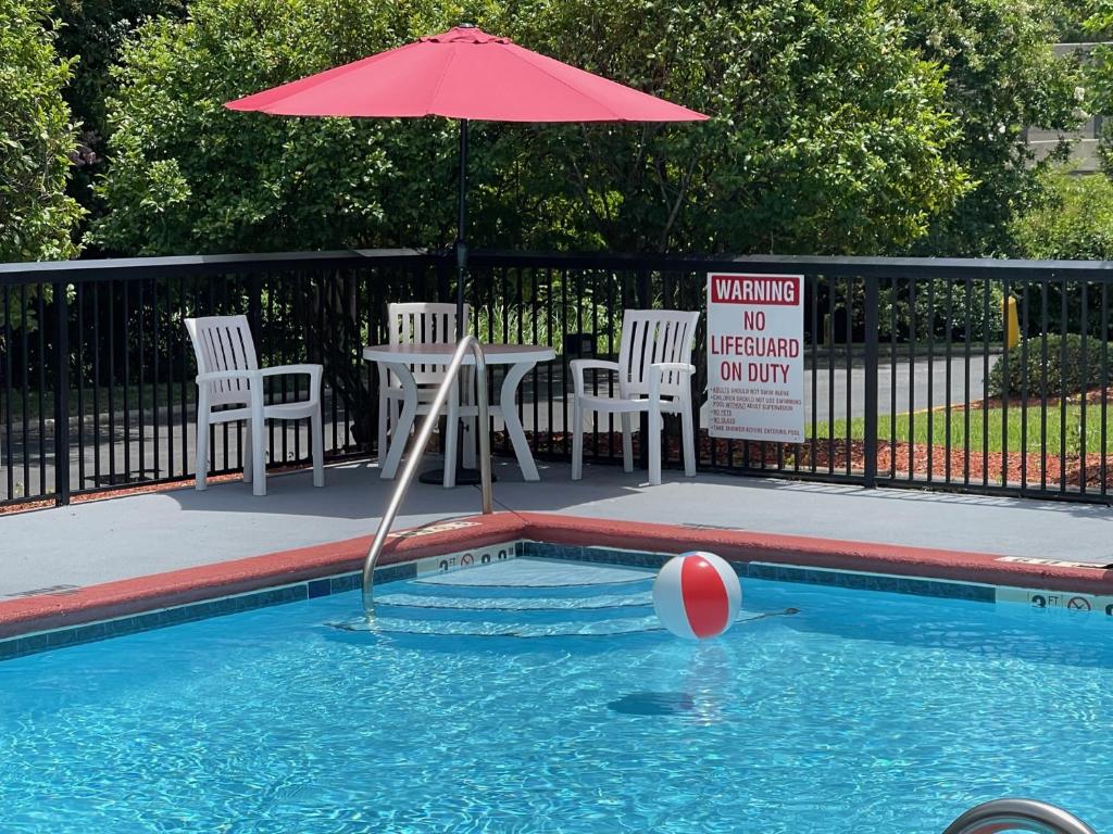 a pool with an umbrella and a ball in the water at Comfort Suites Salisbury I-85 in Salisbury