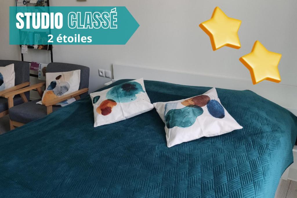 a bed with three pillows on top of it at VITTEL LOC'S - LE 147 - Studio classé 2 étoiles CALME ET COSY in Vittel