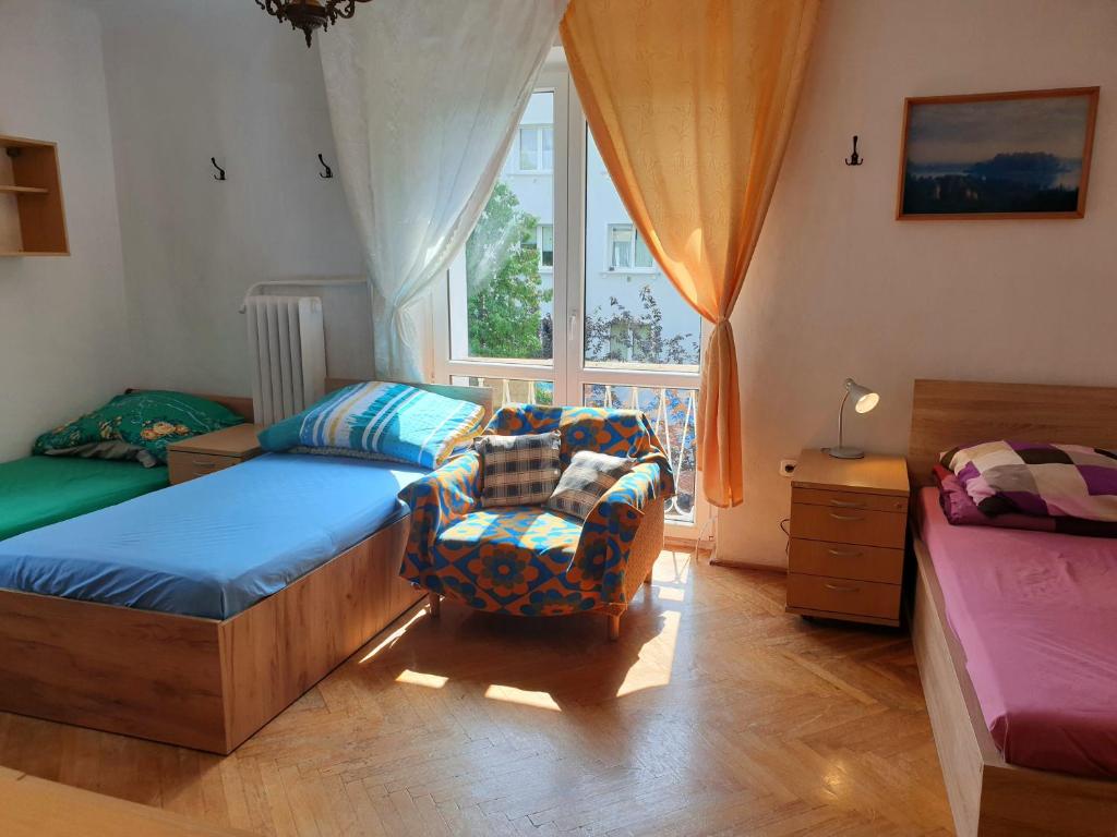 sypialnia z łóżkiem, krzesłem i oknem w obiekcie Rooms by Kino Femina w Warszawie