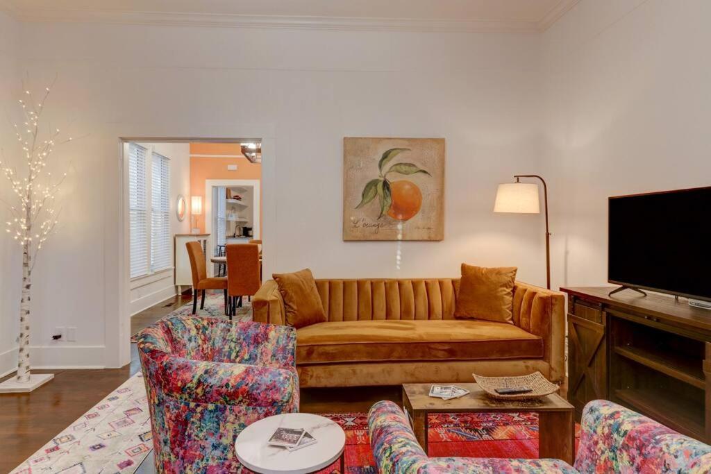 uma sala de estar com um sofá e uma televisão em NEW! Orange Street Downtown Cottage em Hot Springs