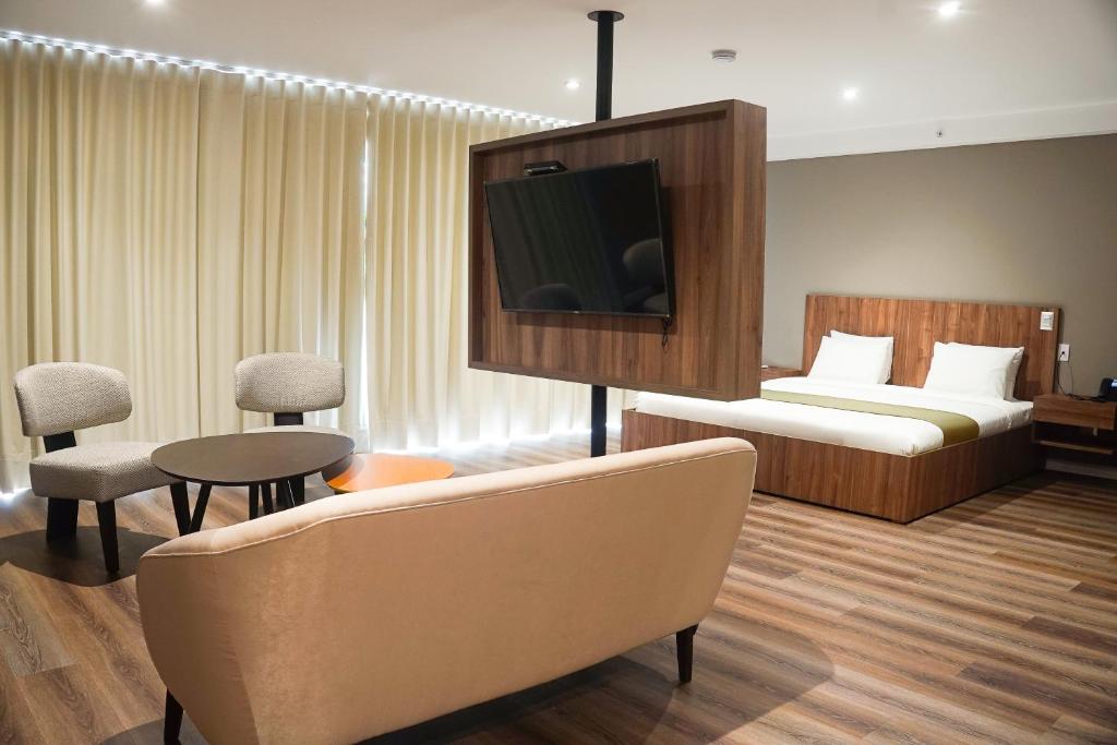 um quarto de hotel com uma cama e uma televisão em Equo Hotel Boutique em Lima