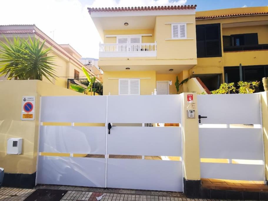 una cerca blanca frente a una casa en Amplia casa 5 habitaciones en Santa Cruz con zona para trabajar en Santa Cruz de Tenerife