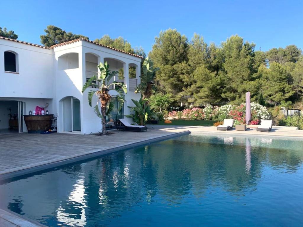 une maison avec une piscine devant dans l'établissement Villa vue mer et pinède, à Bandol