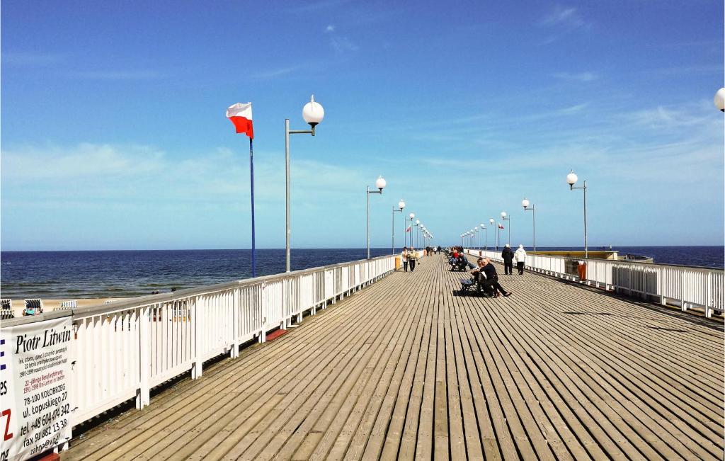a boardwalk with people walking on it on the beach at Cozy Apartment In Kolobrzeg With Wifi in Kołobrzeg
