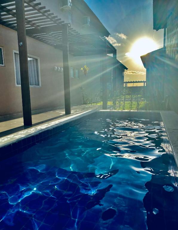 a swimming pool with blue water in a building at Bangalô 39 in Tamandaré