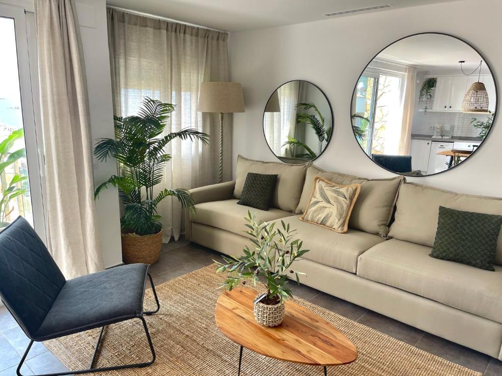 uma sala de estar com um sofá e um espelho redondo em SeaHomes Vacations - MARINA BOUTIQUE design em Santa Susanna