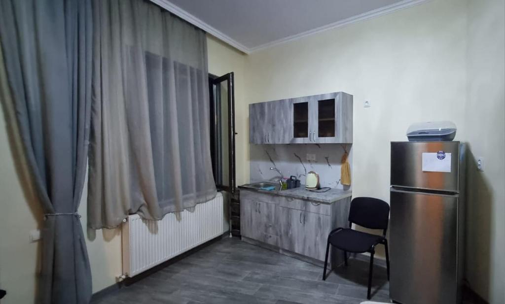 una pequeña cocina con nevera y mesa en Guest House 27, en Tiflis