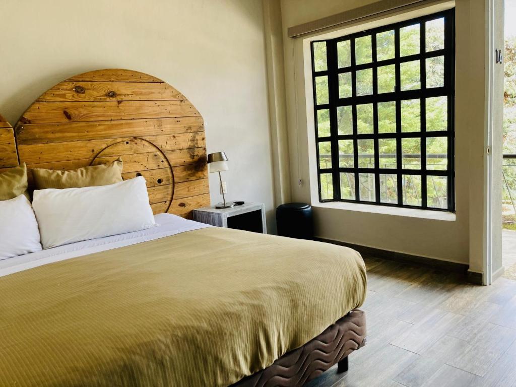 a bedroom with a large bed and a large window at Hotel Rocaval San Cristóbal de las Casas in San Cristóbal de Las Casas
